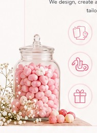 Glass jar filled with pink sweets beside delicate flowers