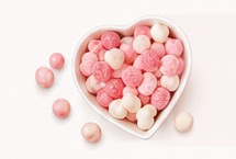 Pink and white sweets arranged in a heart shaped bowl